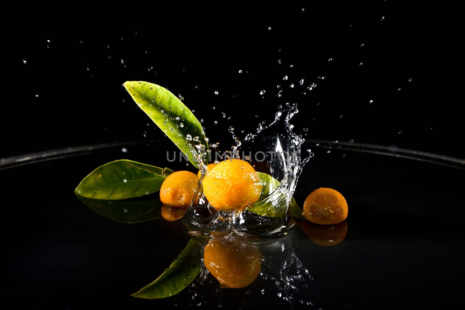 citrus fruit falling in water drops splashing everywhere. Concept of freshness and purity.