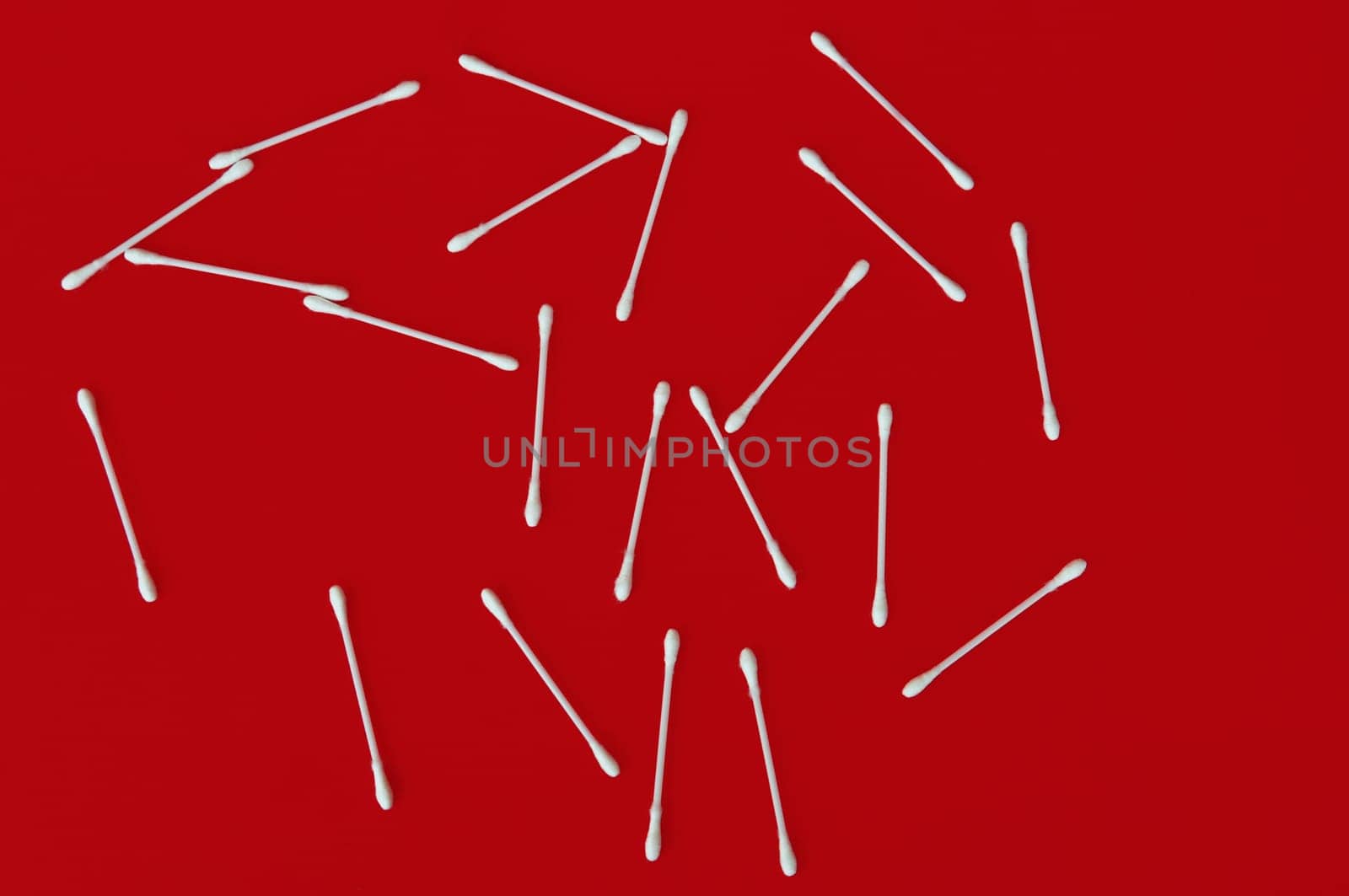 Ear buds white cotton swabs on red background.