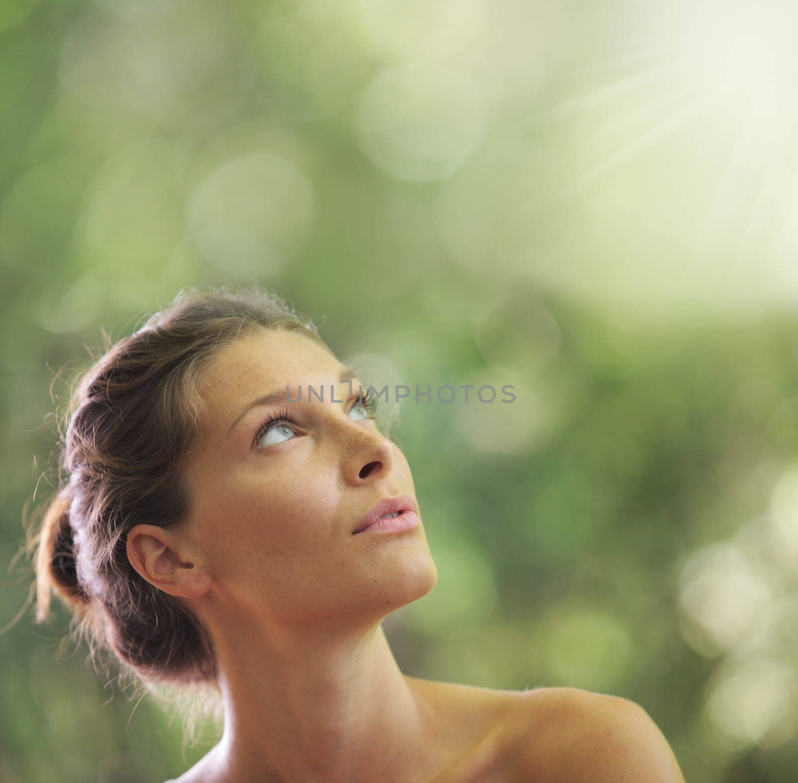 Portrait close up of young beautiful woman, on green background. Looking up