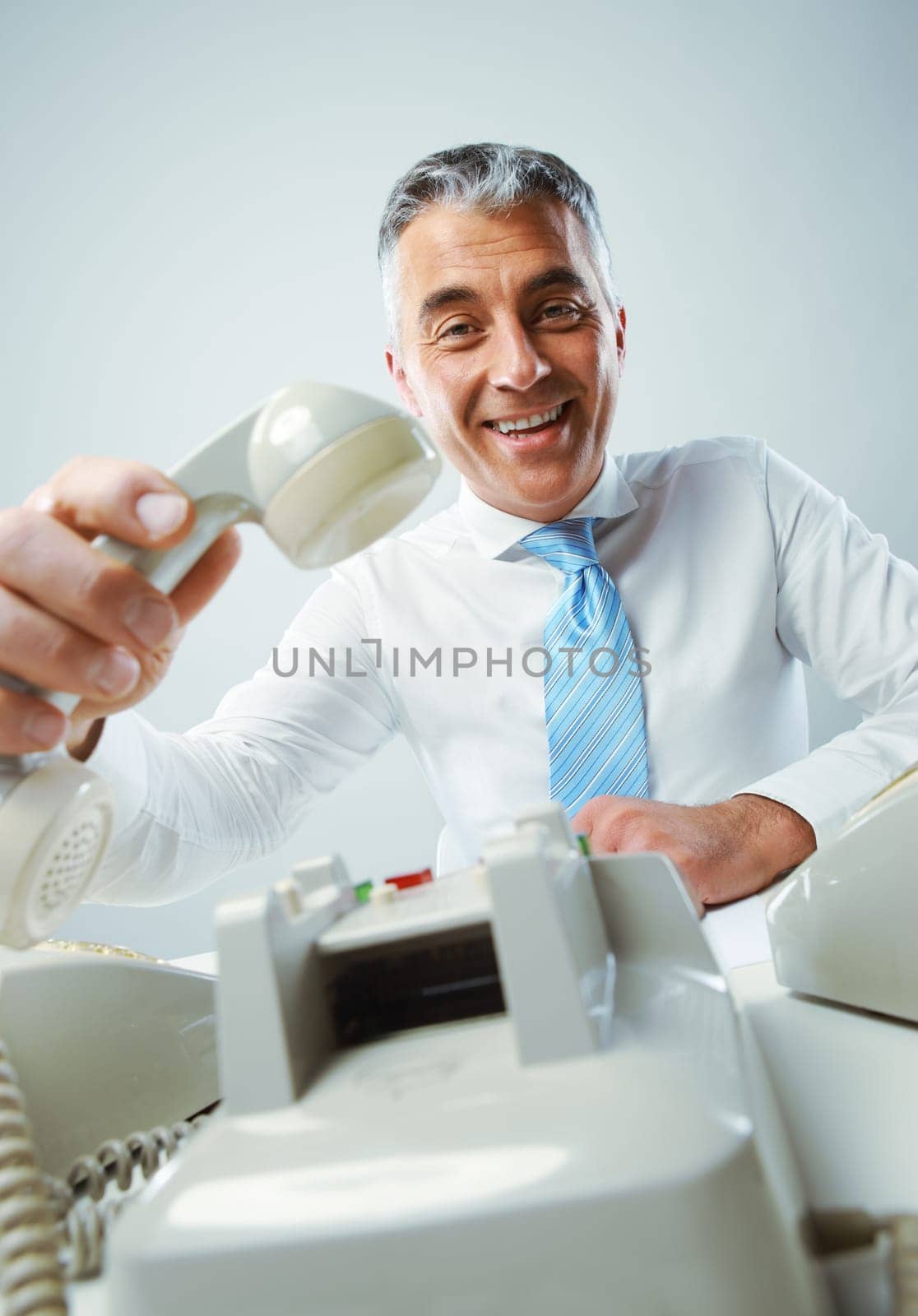 Portrait of a smiling mature business man with phone