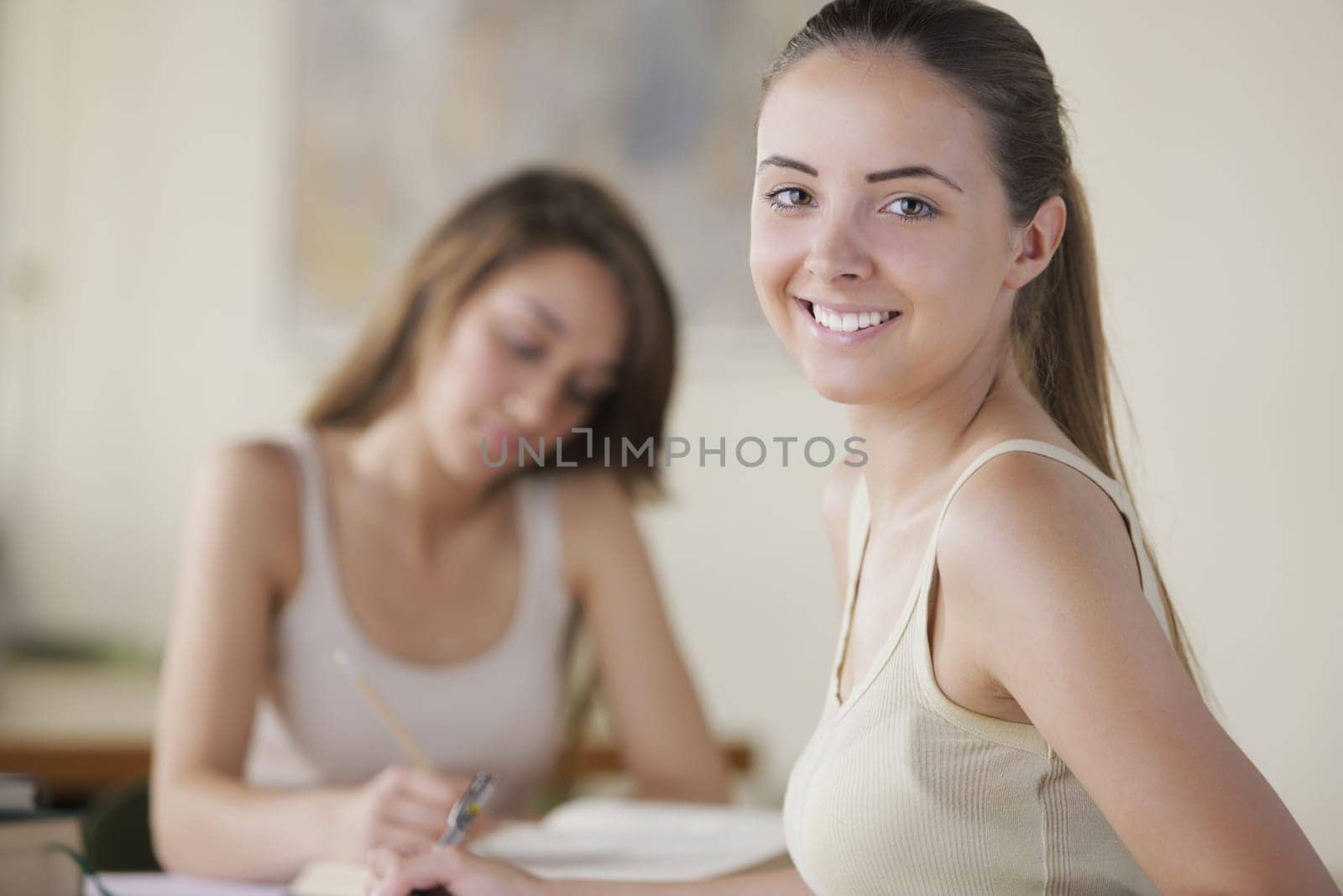Portrait of a student, a young woman studying in the background