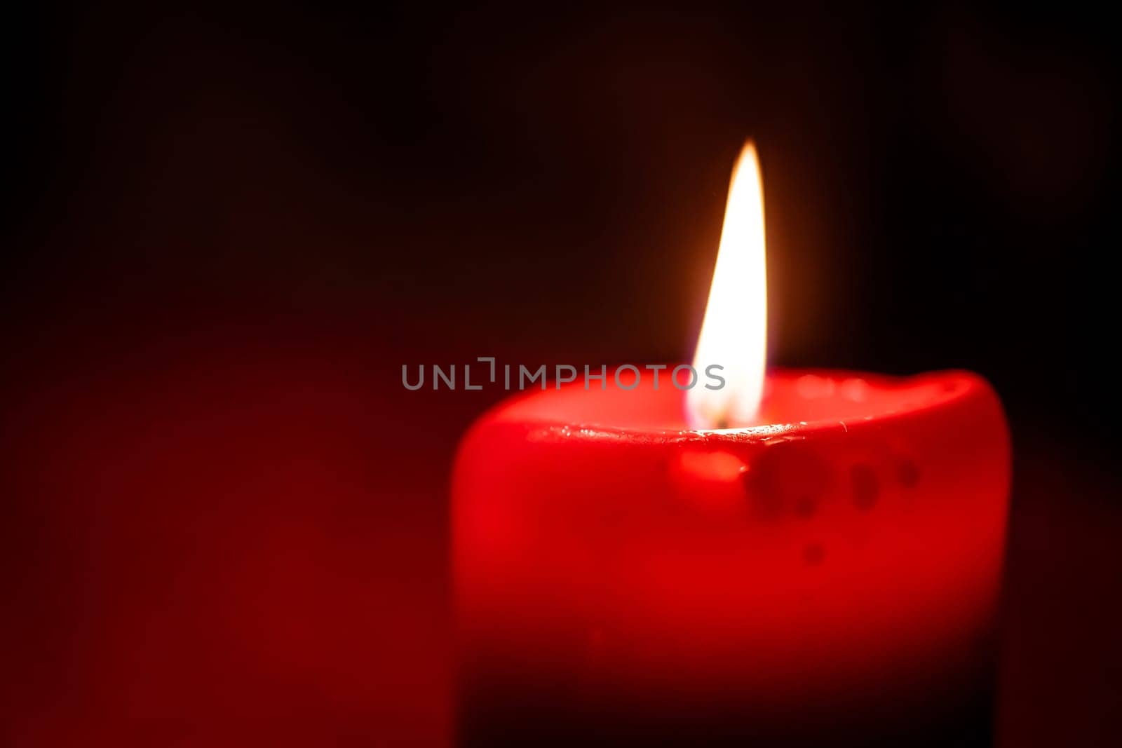 Close-up photo of a flaming red candlelight at christmas time