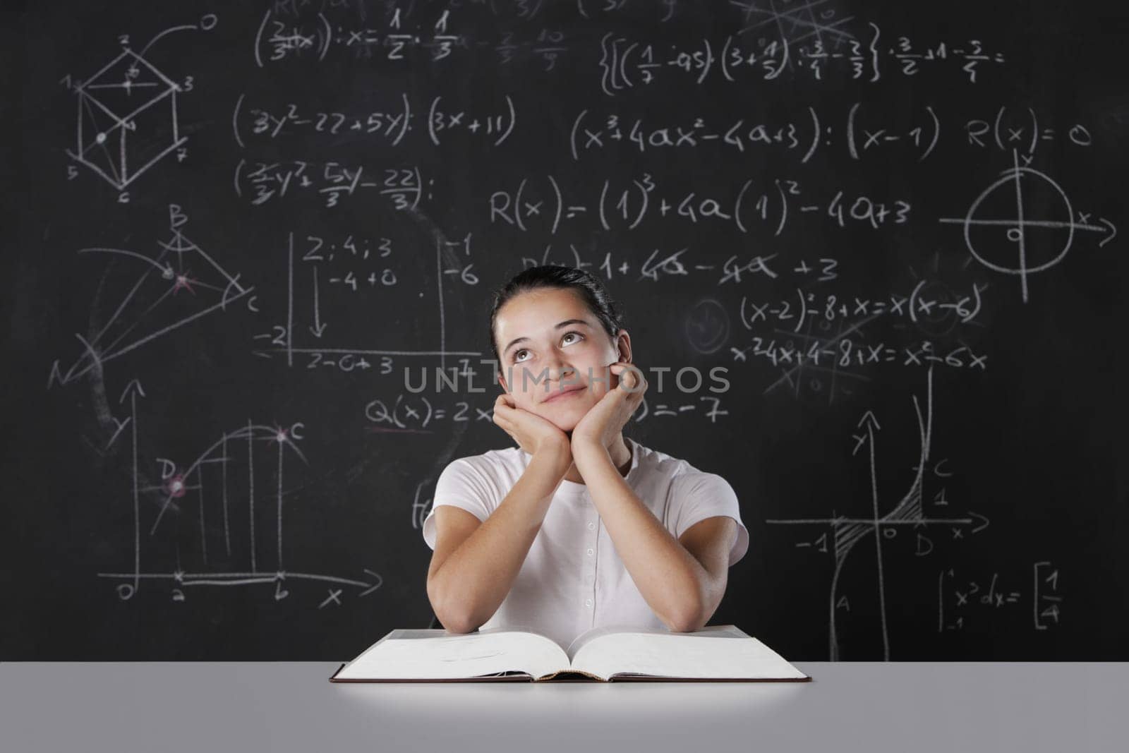 Student sitting in front of a blackboard filled with mathematical formulas. thinks about his future
