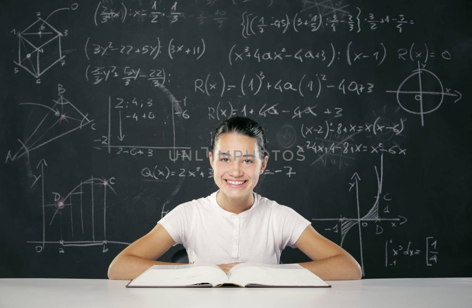 Student sitting in front of a blackboard full of math formulas