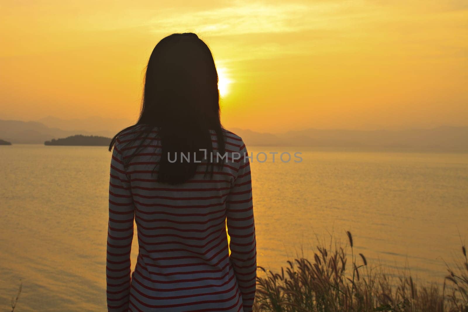 young girl sitting and have a relax under sunset scene
