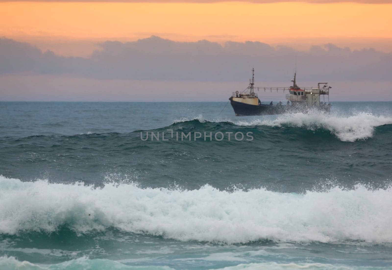 Fishing trawler off the coast off South Africa at sunset