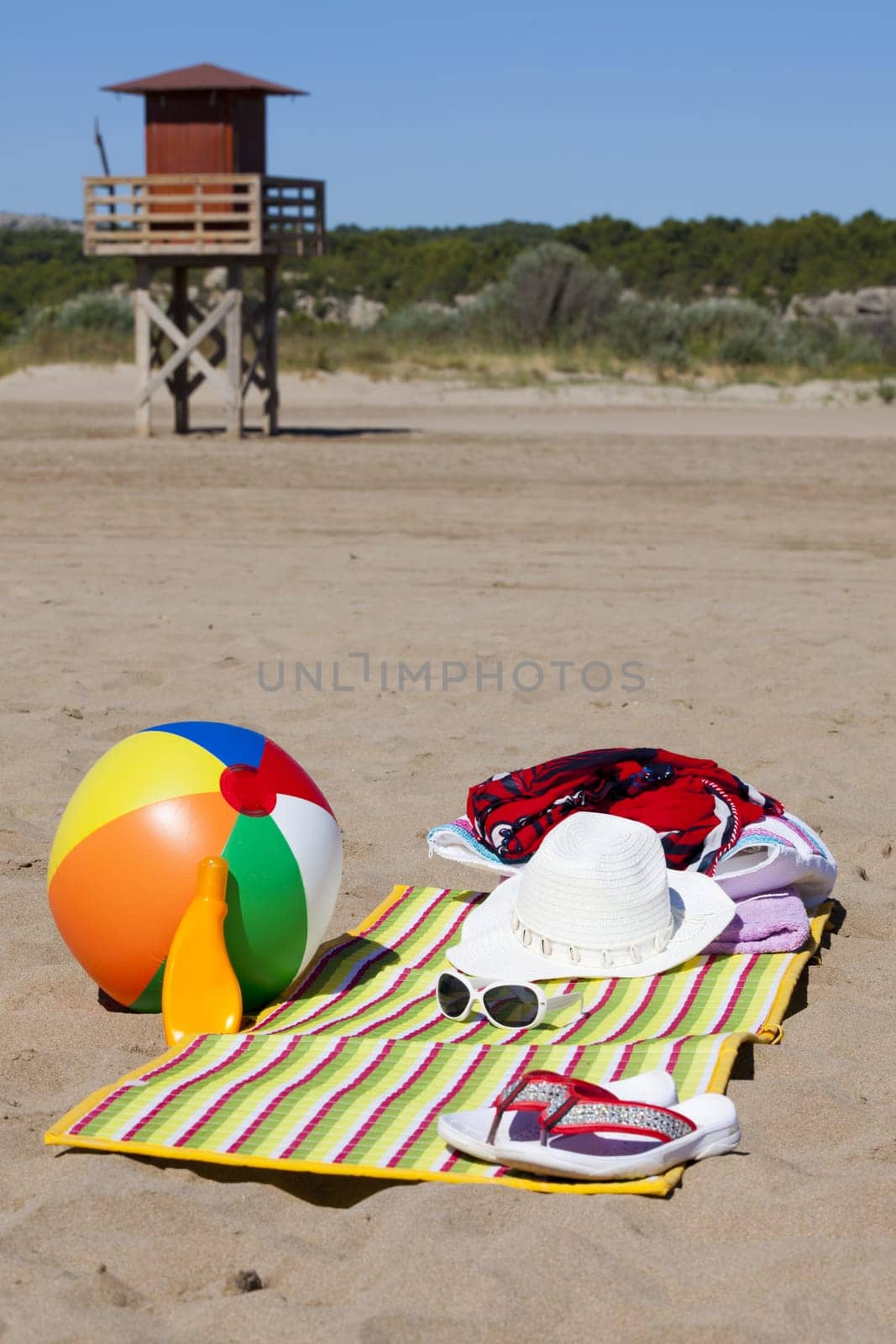 Beautiful beach with beach accessories and a tower in the background