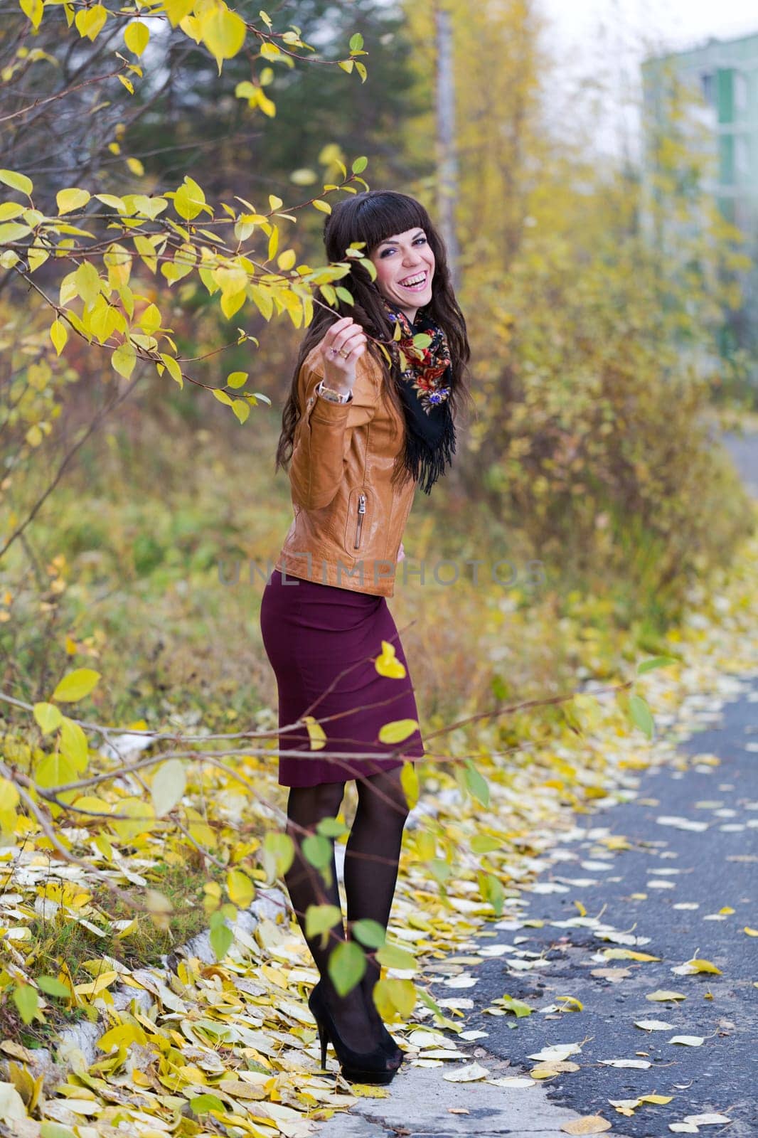 The beautiful girl in the autumn forest smiling
