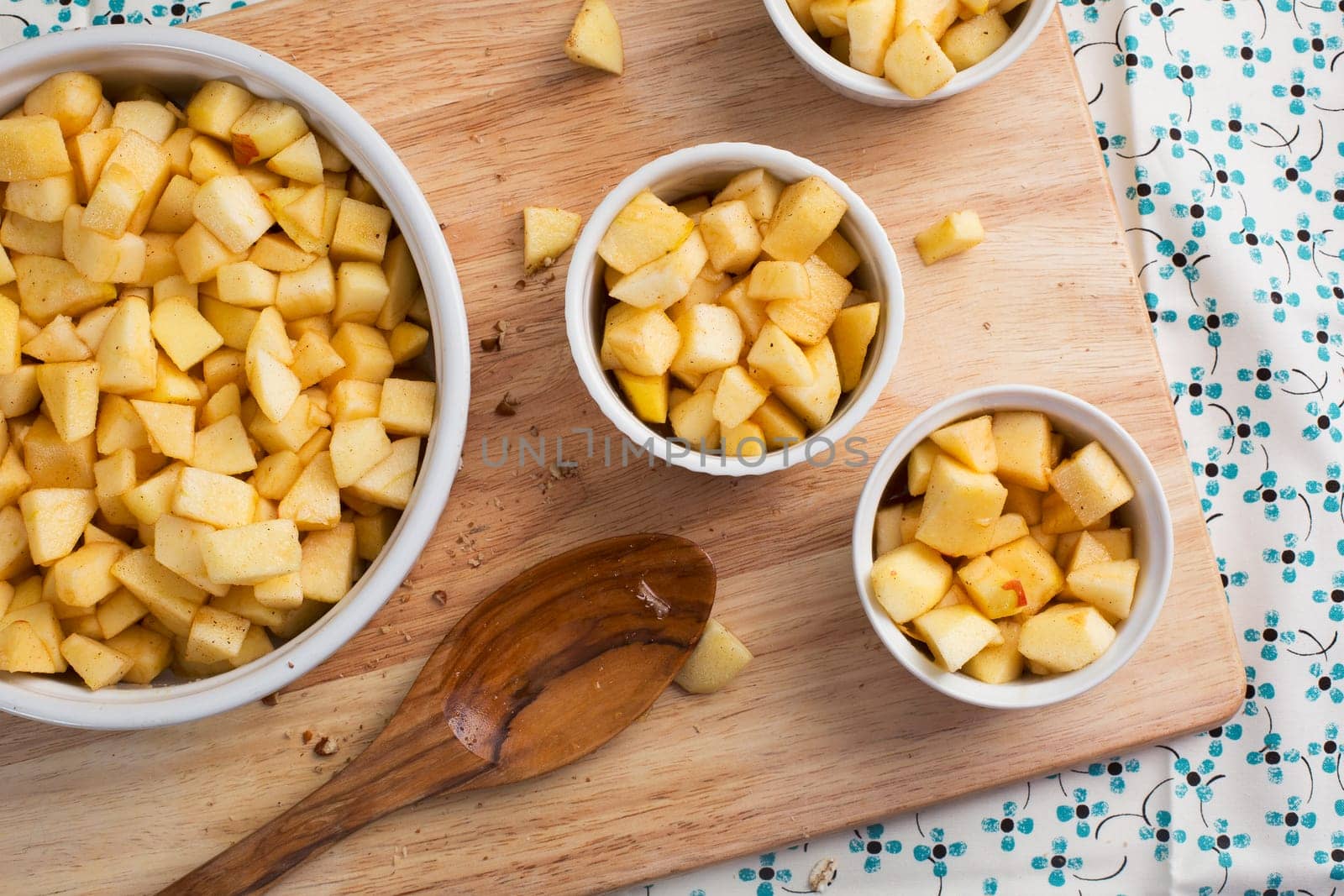 Chopped apples with sugar and spices in baking dishes.