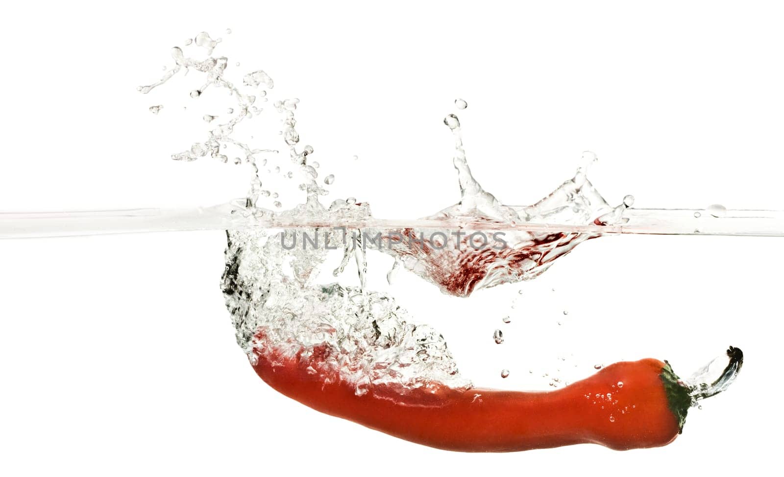Close up on Red pepper splashing into water isolated on white