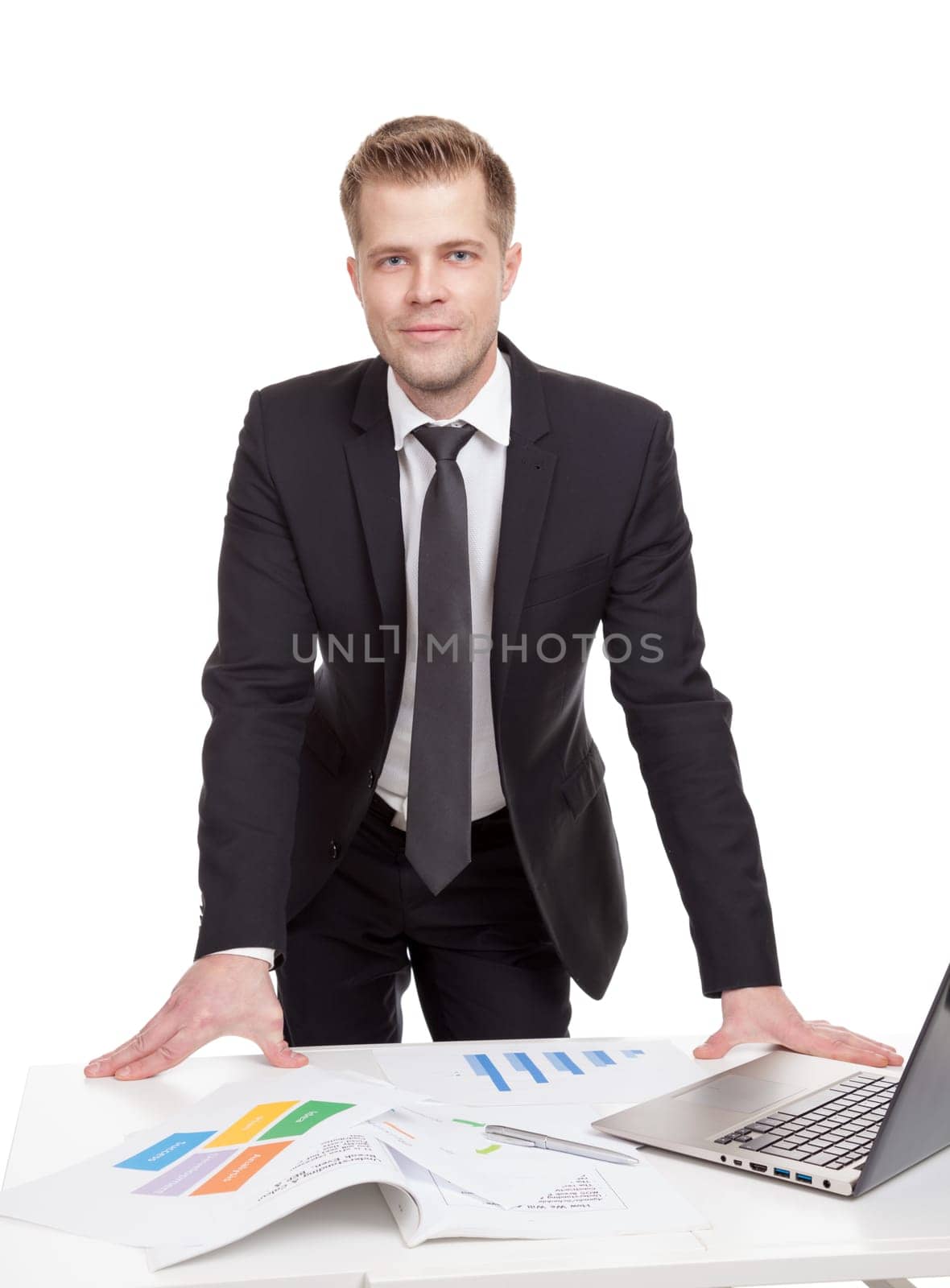 Handsome businessman standing behind the office desk