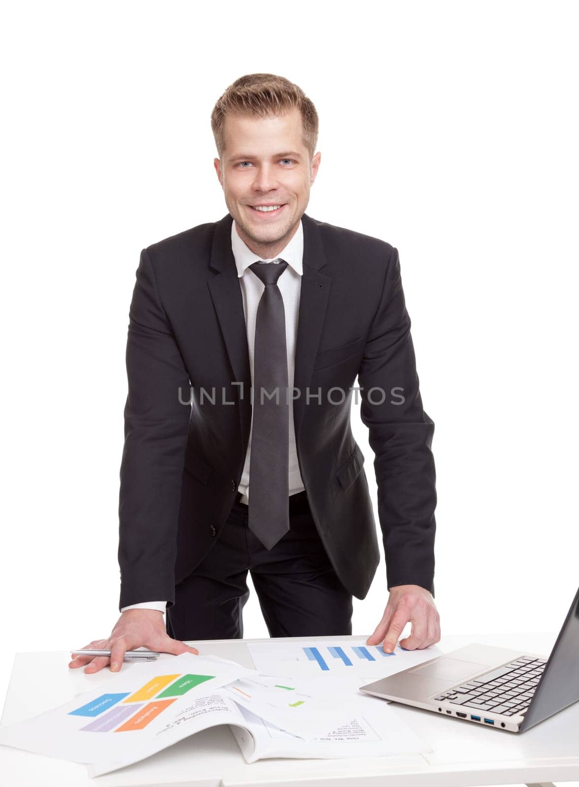 Handsome businessman standing behind the office desk
