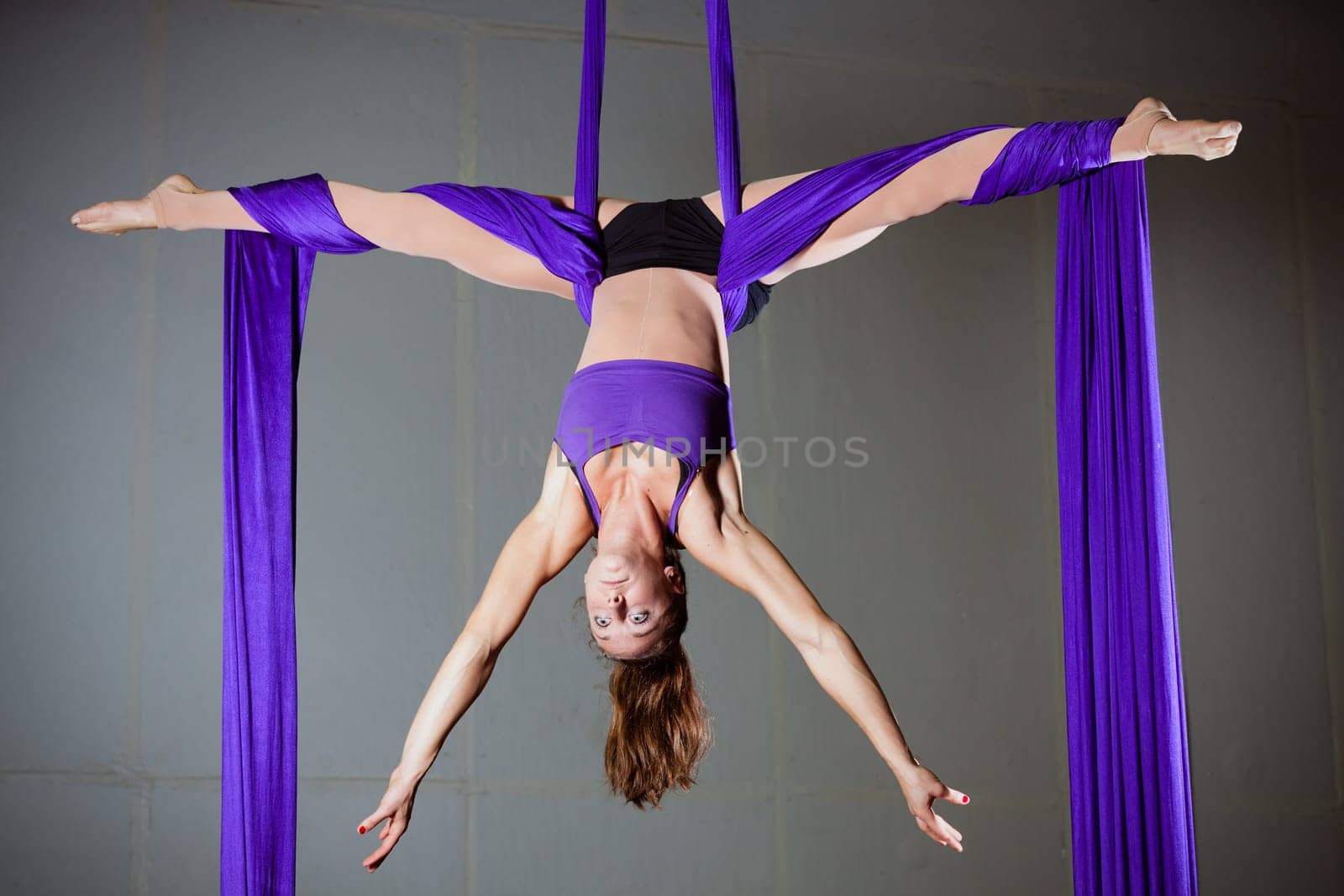 Beautiful woman gymnast performing aerial exercises
