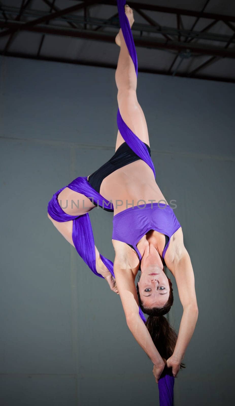 Beautiful woman gymnast performing aerial exercises
