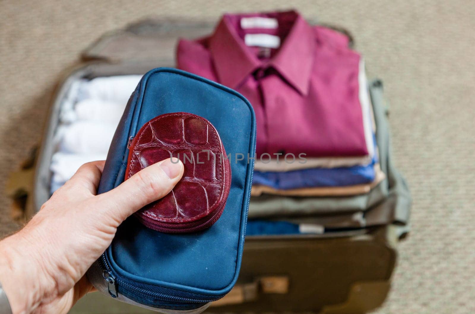 A man is packing suitcase at home for a business trip