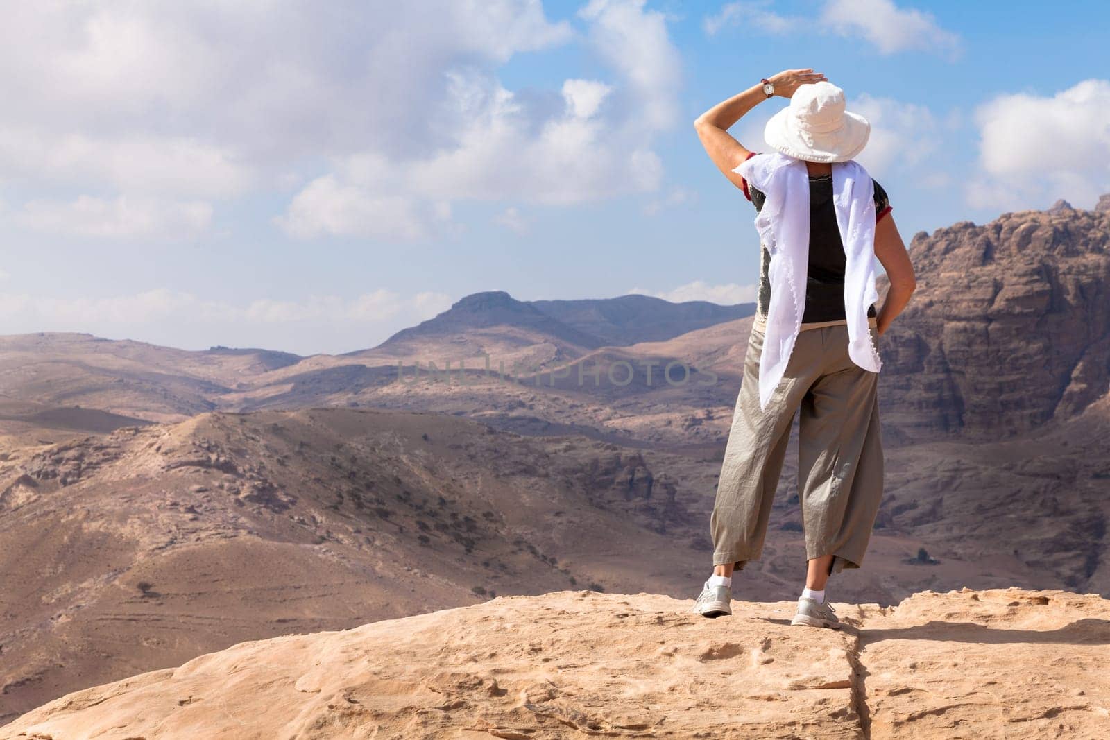 Woman is admiring a view of Jordanian desert while hiking in Petra.