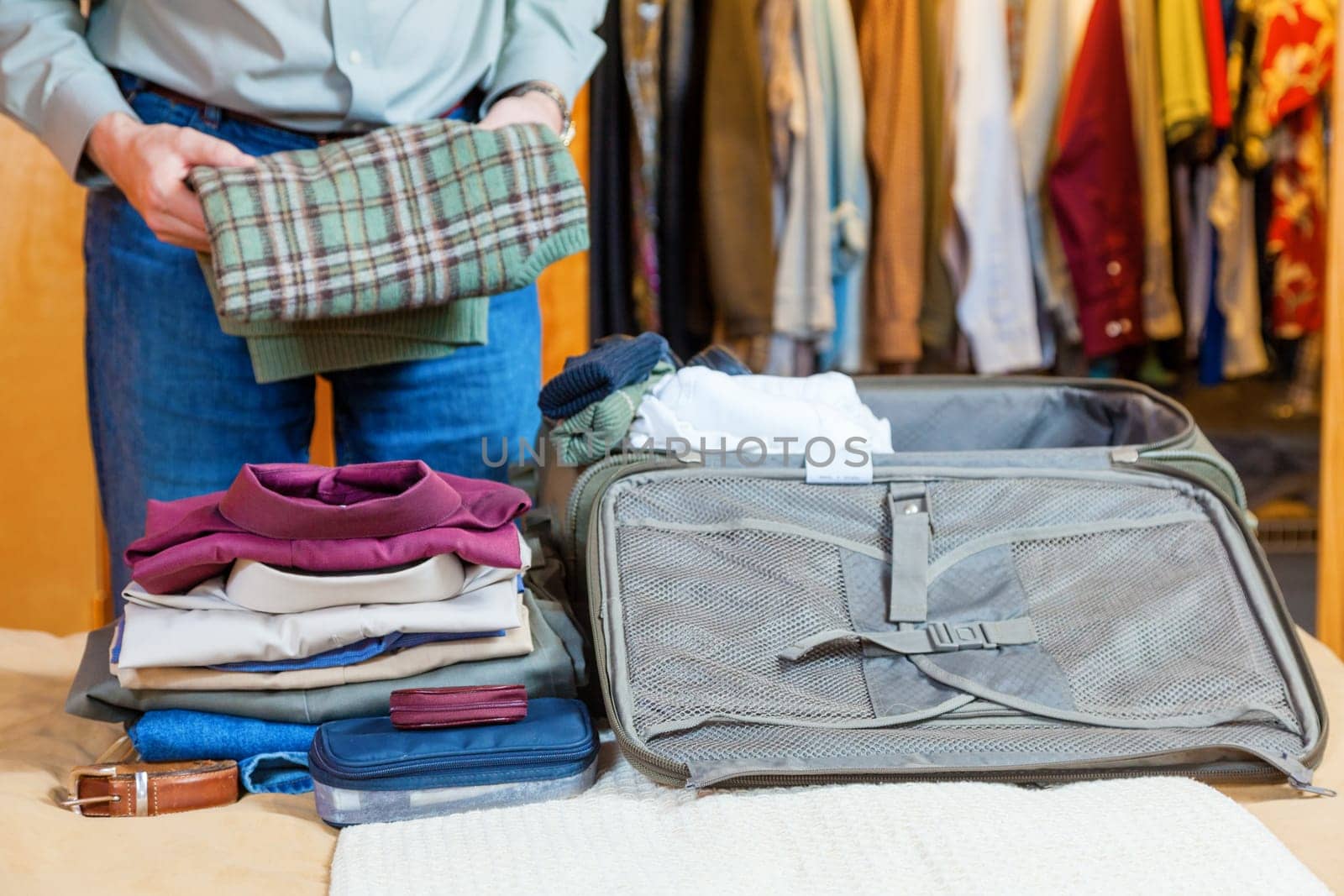 A man is packing suitcase at home for a business trip