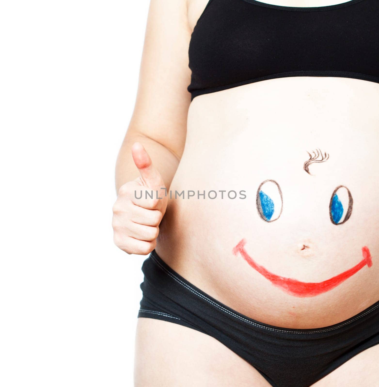 Painted happy smiley face on the belly of pregnant woman