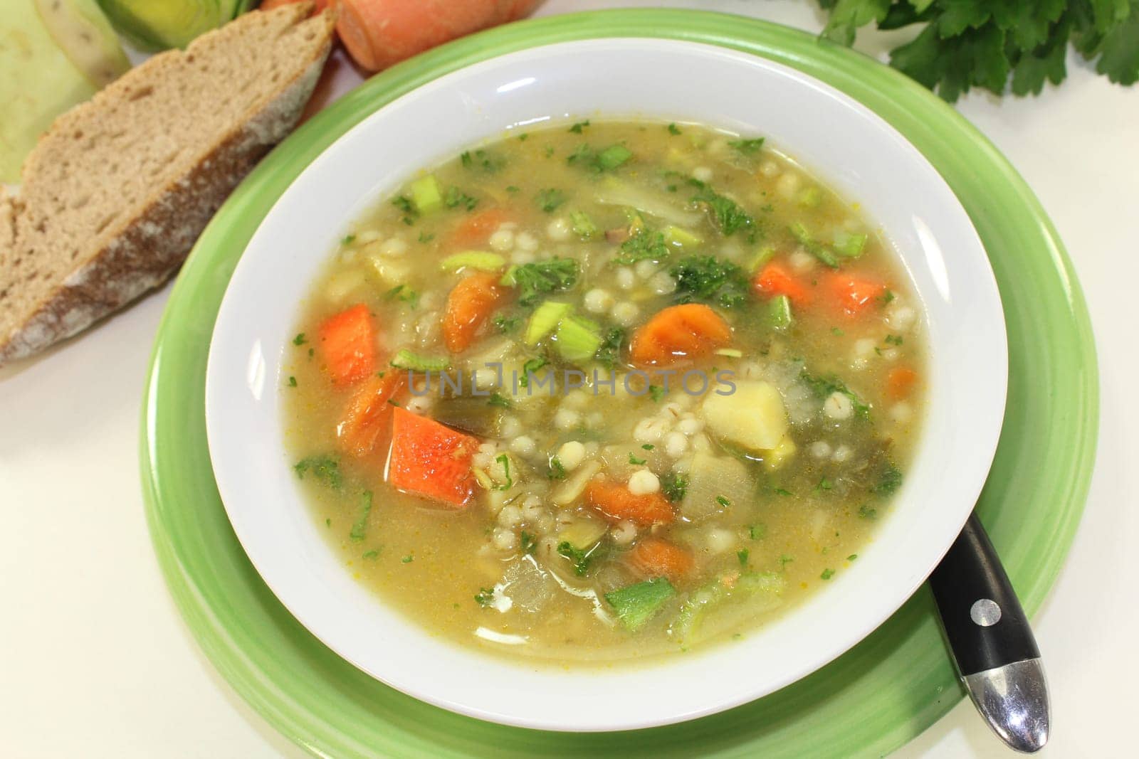 a white bowl of colorful pearl barley soup