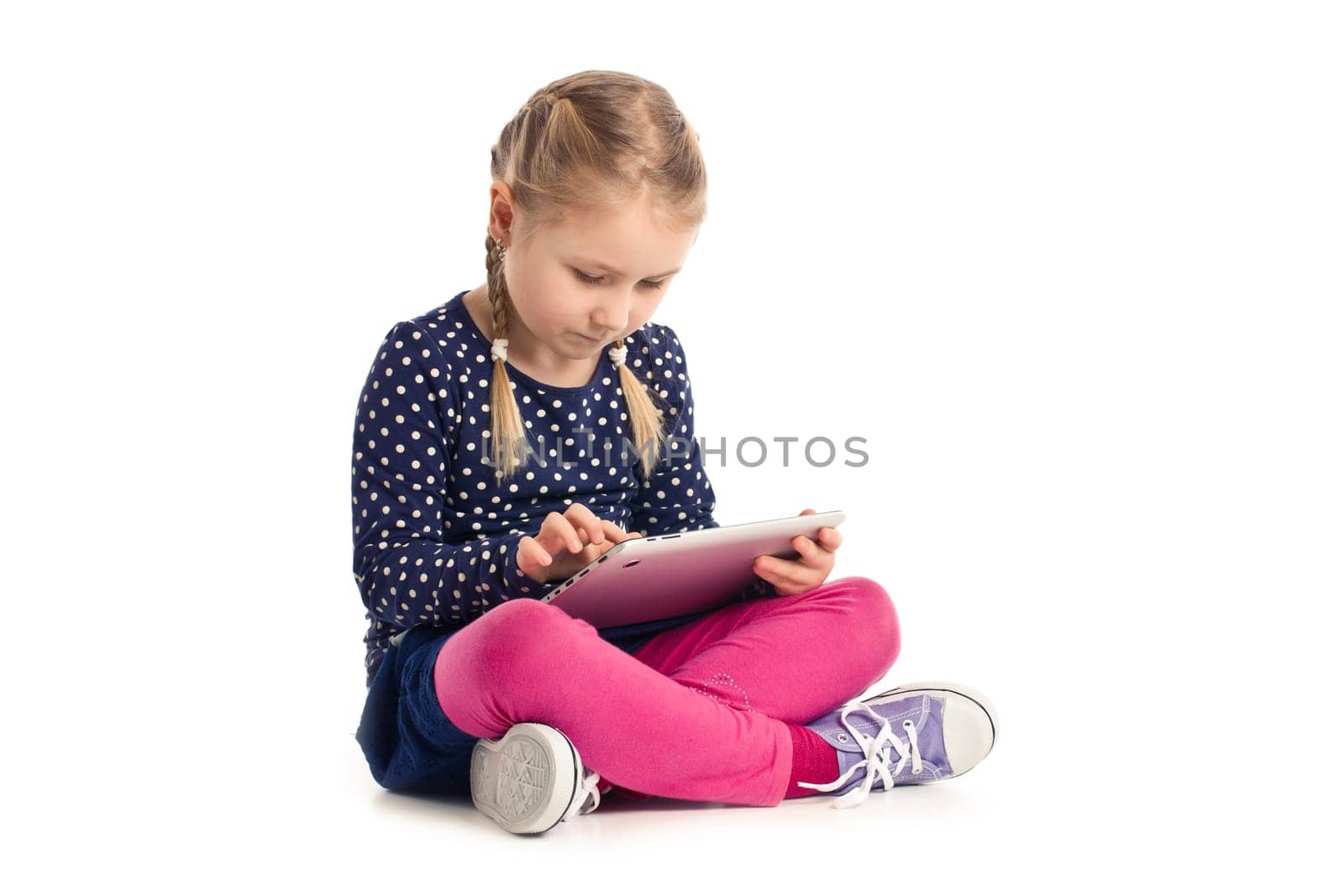 little sitting girl with tablet on white background