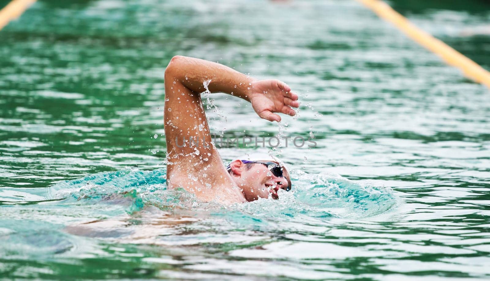 Young man swimming the front crawl in a pool