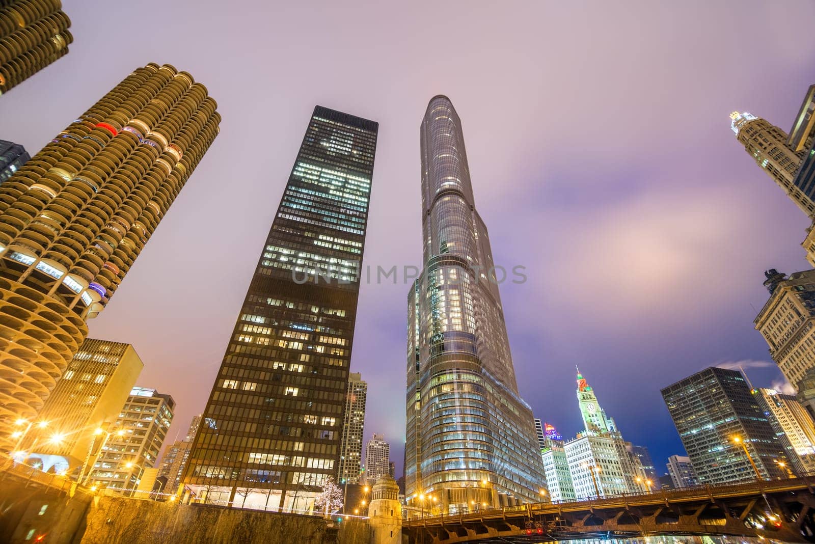View of skyscrapers in Chicago at night as seen from the banks of the Chicago River