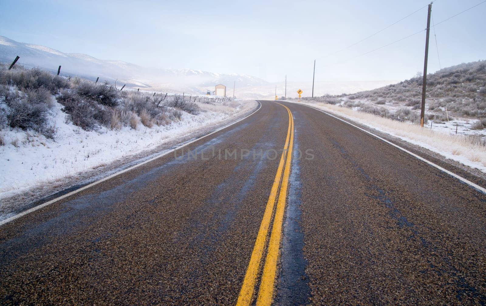 An icy road leads through country scene farm ranch hillside highway 71