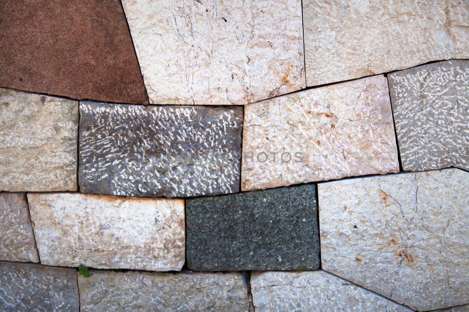 Stone wall with add shaped blocks and various colors and textures of stones