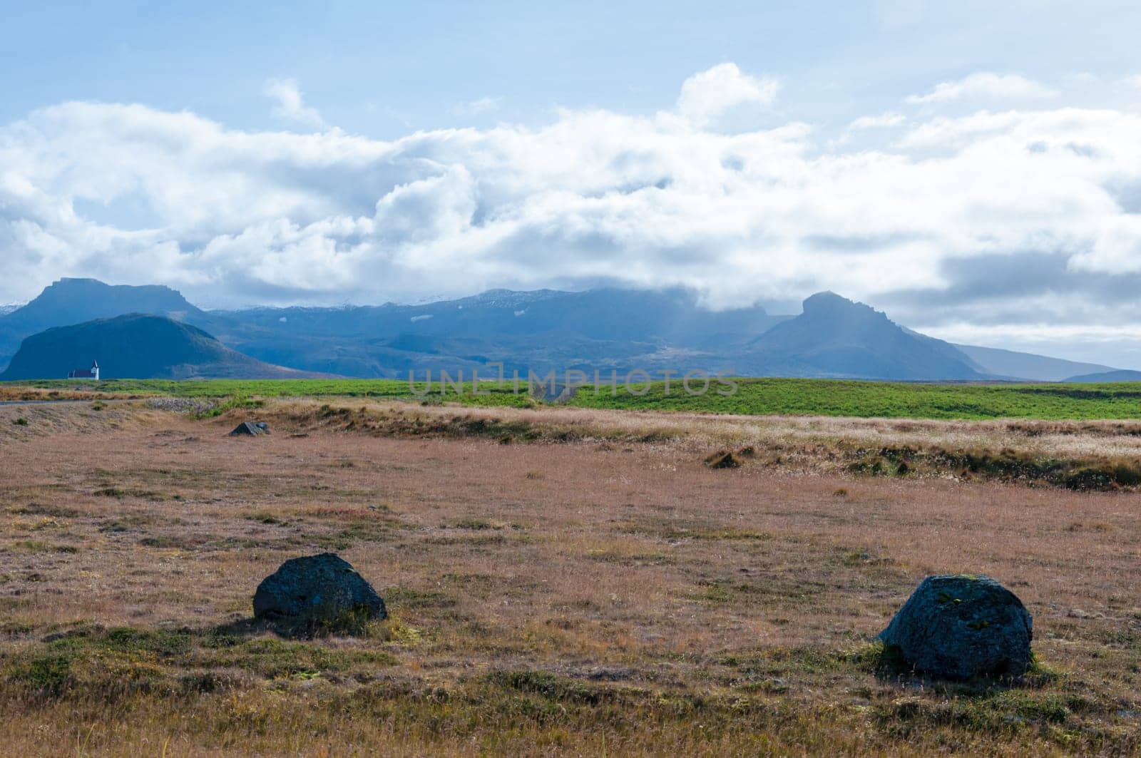 Icelandic landscape with volcanic rocks and green grass