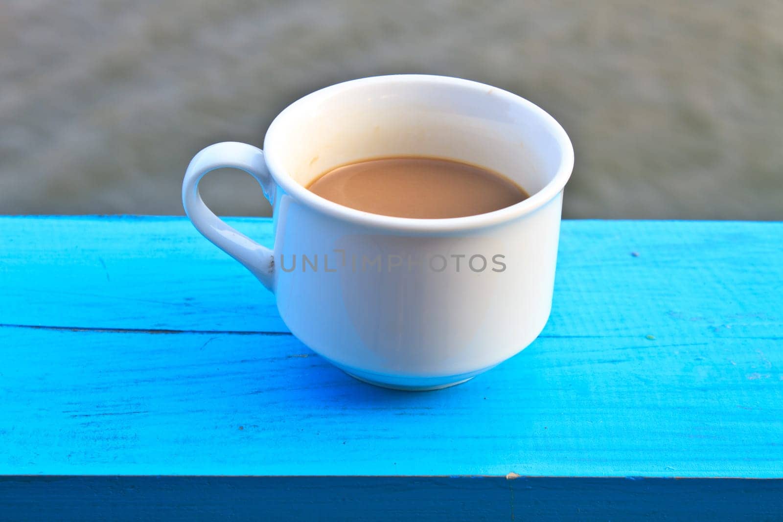 hot coffee in white cup on wooden, During leisure time on river background