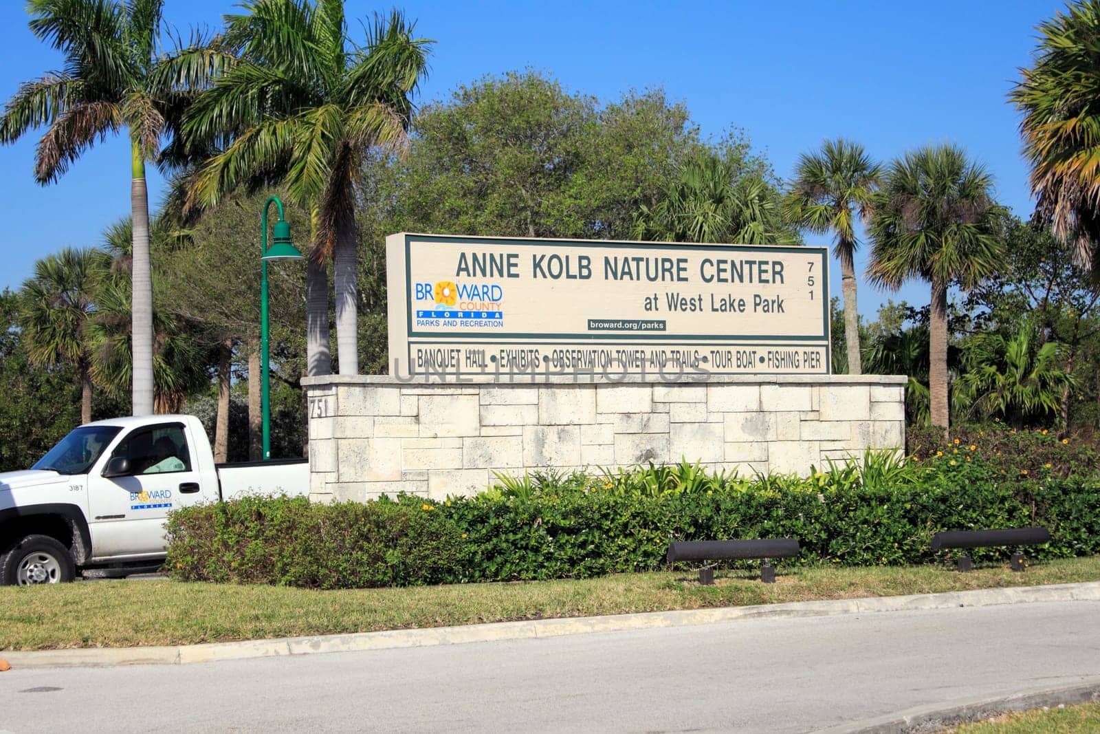 HOLLYWOOD, FLORIDA - FEBRUARY 20, 2013: Very large sign seen from the street with lots of trees and foliage in the background welcoming visitors to Center at West Lake Park on a sunny tropical day.