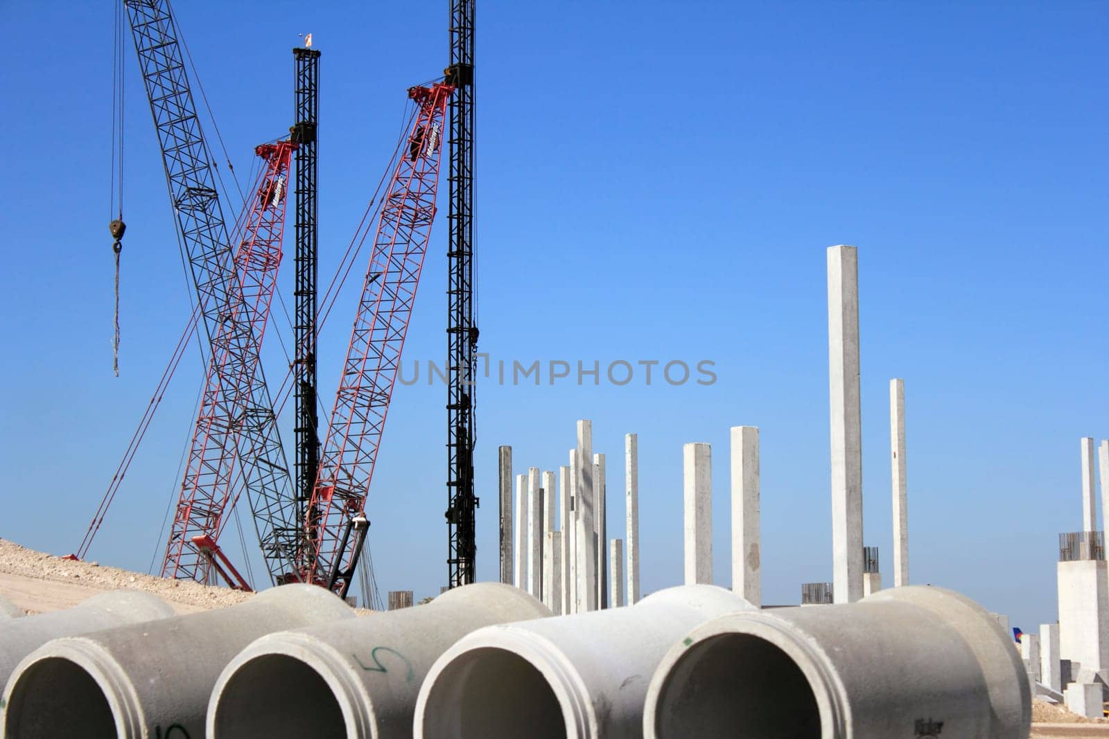 FORT LAUDERDALE, FLORIDA - FEBRUARY 20, 2013: Lots of construction cranes, pylons, rebar, and cement sewer pipes near sandy hills on a sunny day at the Fort Lauderdale-Hollywood International Airport.
