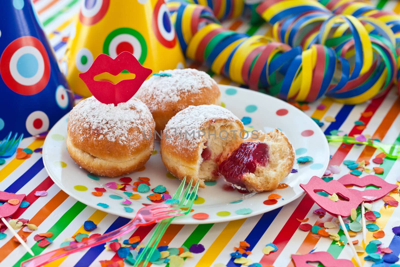 Fresh fritters on a small plate on a colorful striped background
