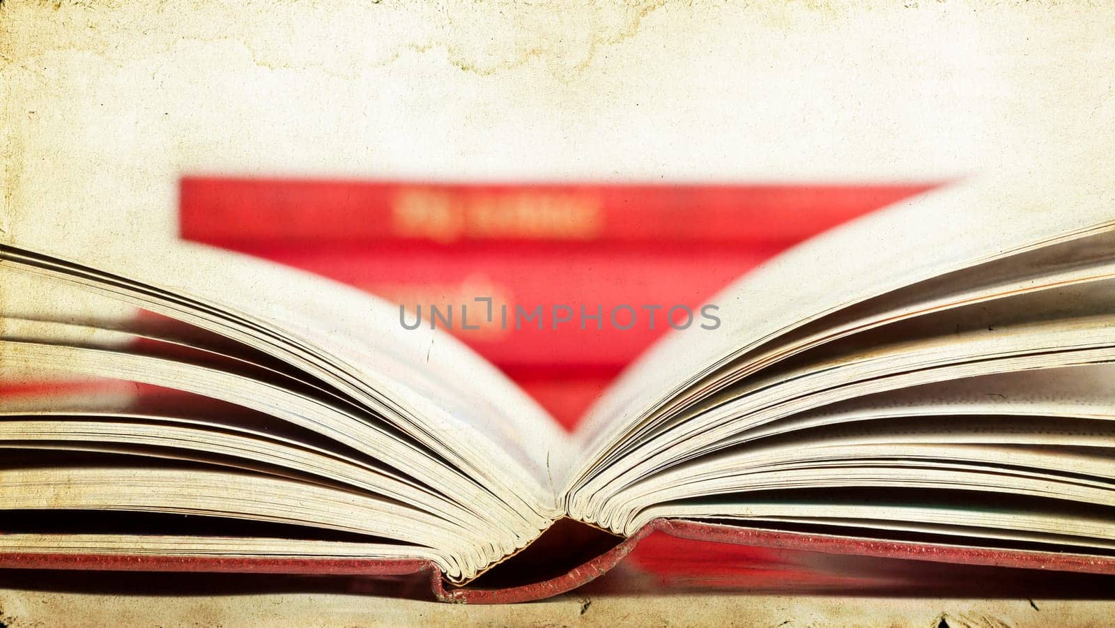 Vintage photo of open book with pile in the background