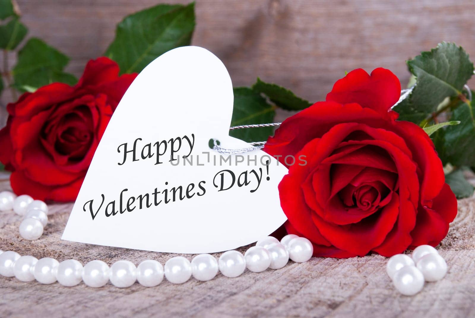 Background with Roses and a white Heart Label with Happy Valentines Day on it