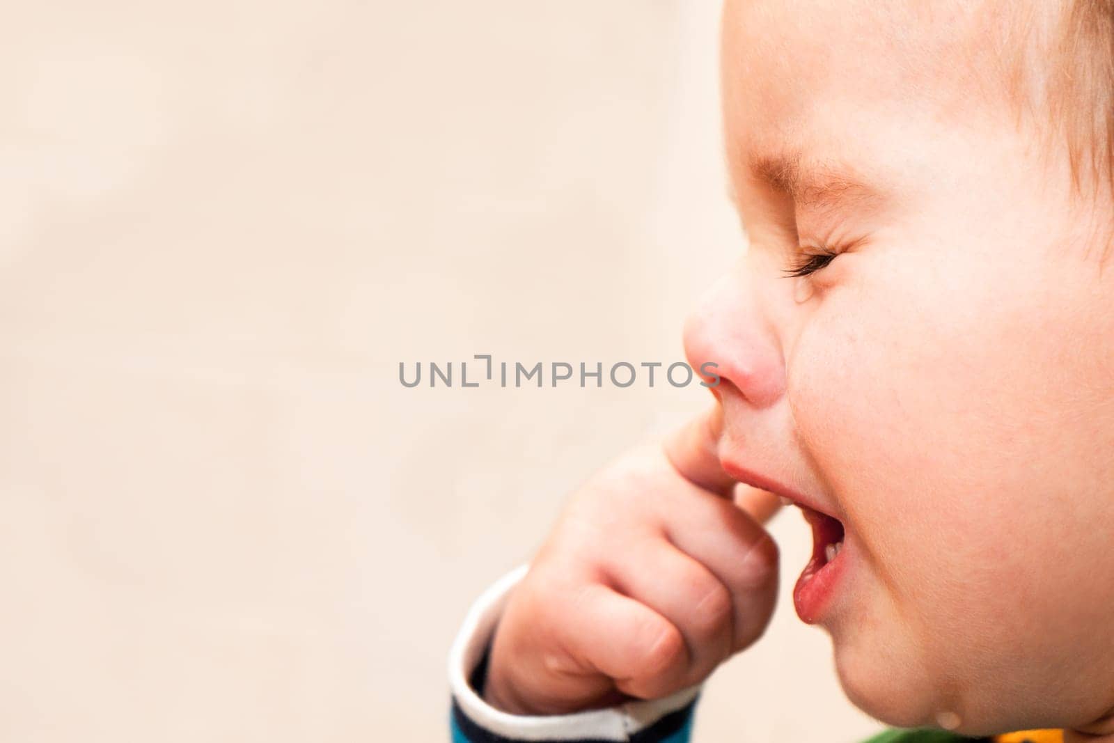 Portrait Of Crying Baby Boy In Home.