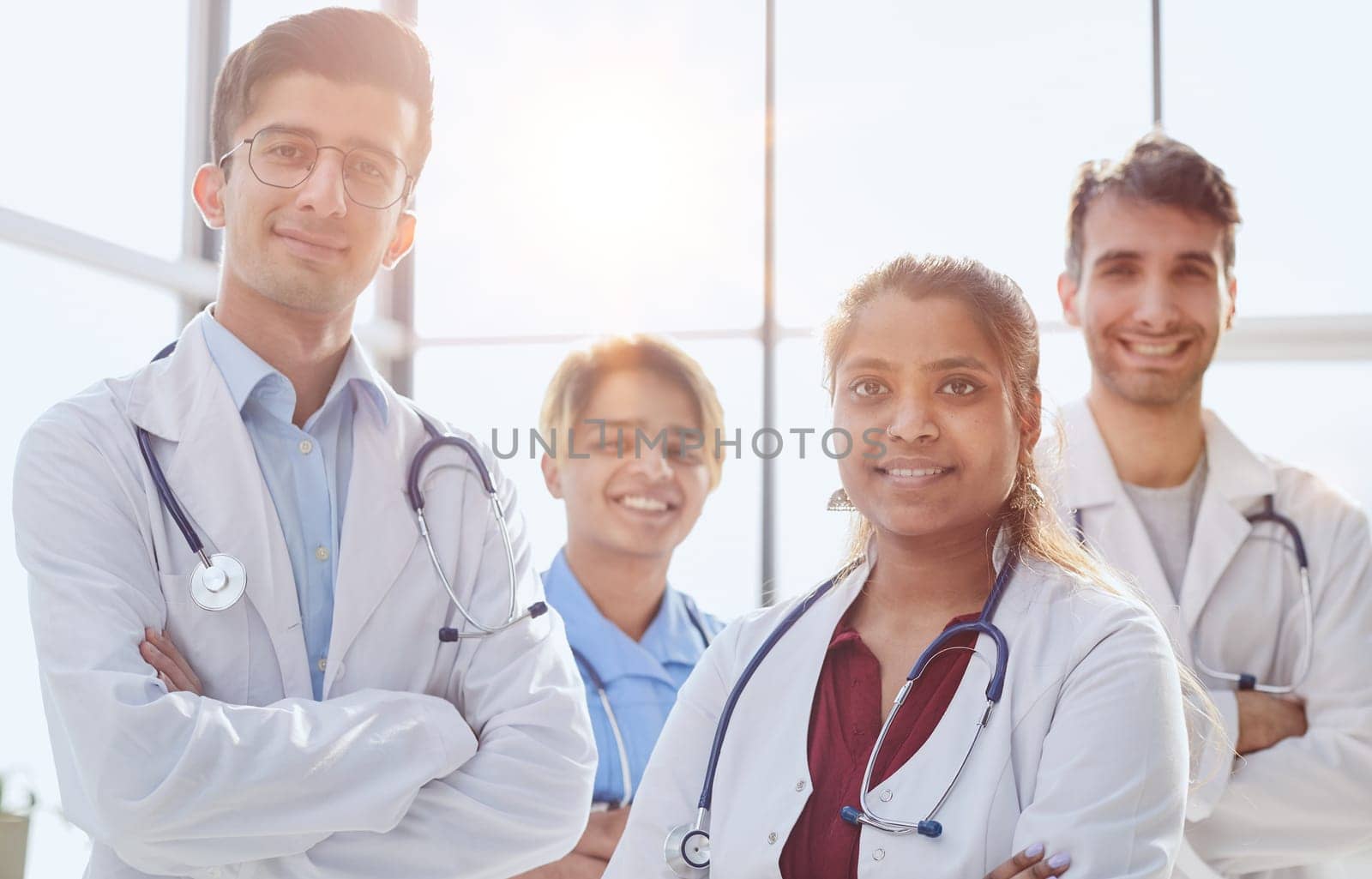Professional multiethnic doctors posing standing in hospital corridor