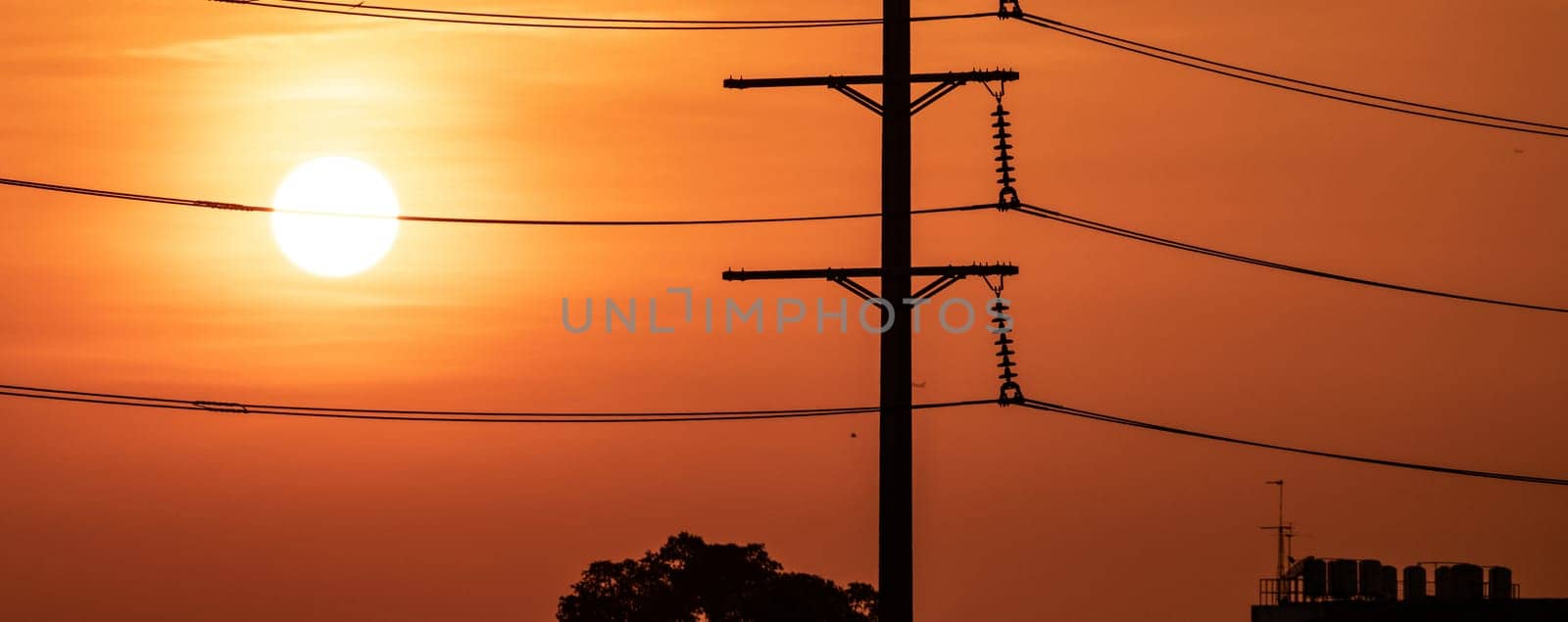 High voltage electric transmission pylon. High voltage power lines against sunset sky. Electricity pylon and electric power transmission lines. High Voltage pole provide power supply. Energy crisis.