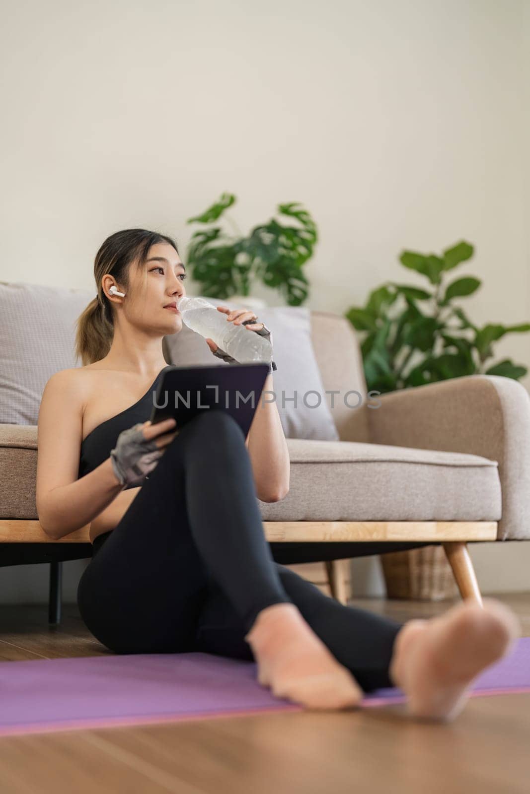 Exercise at home, Asian girl drinking water after workout fitness, Healthy asia woman training weight fit sport for body strength, Female exercising in home living room.