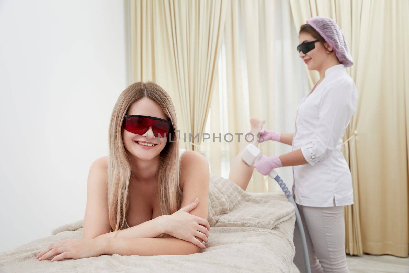 Woman at the salon lies down for a laser hair removal procedure on her legs