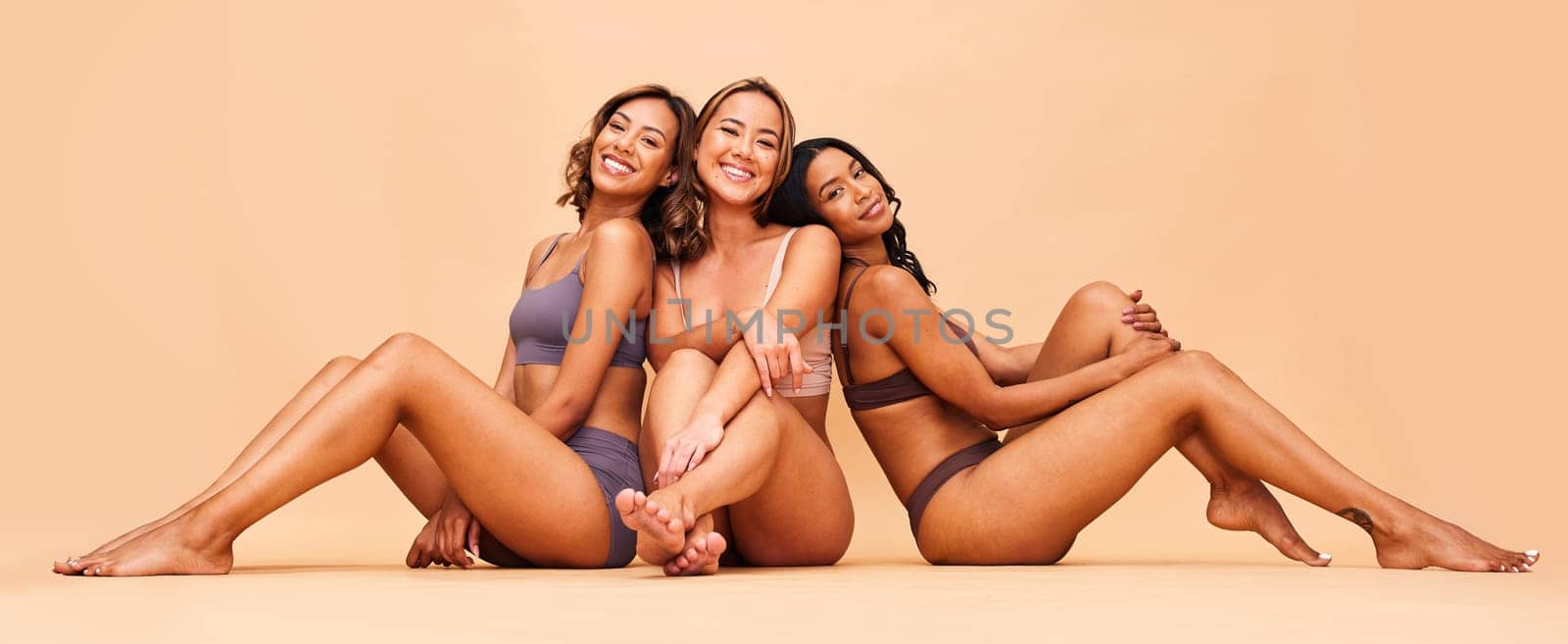 Beauty, group and happy women sitting with makeup for cosmetic skincare isolated in a studio brown background. Skin, aesthetic and portrait of friends together for self care, dermatology and support.