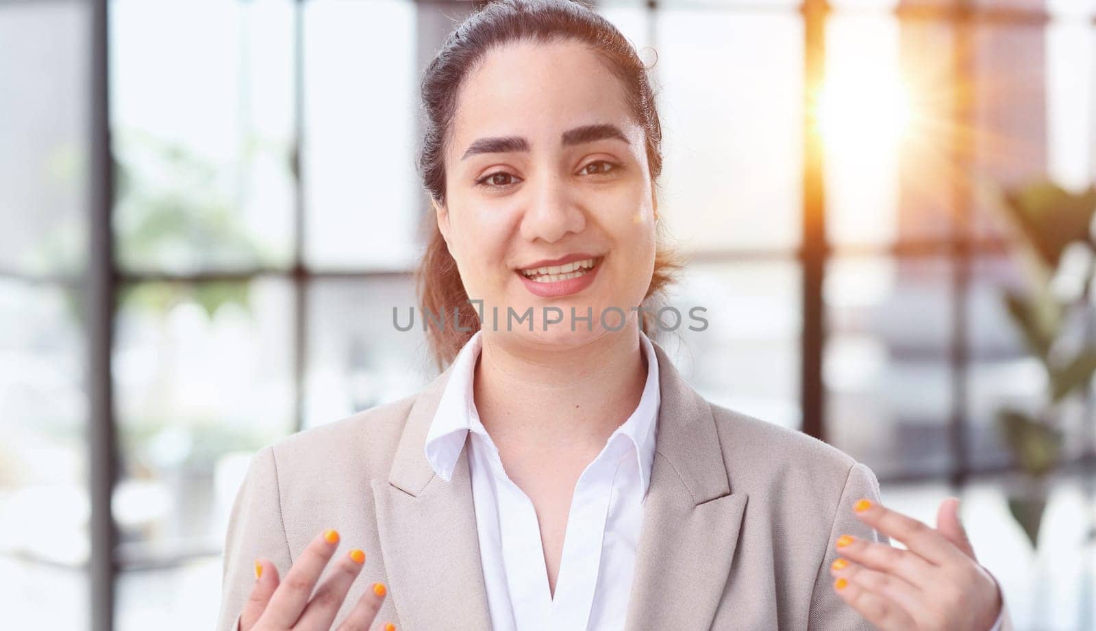 Young smiling latin girl college student or teacher looking at camera standing in university campus. by Prosto