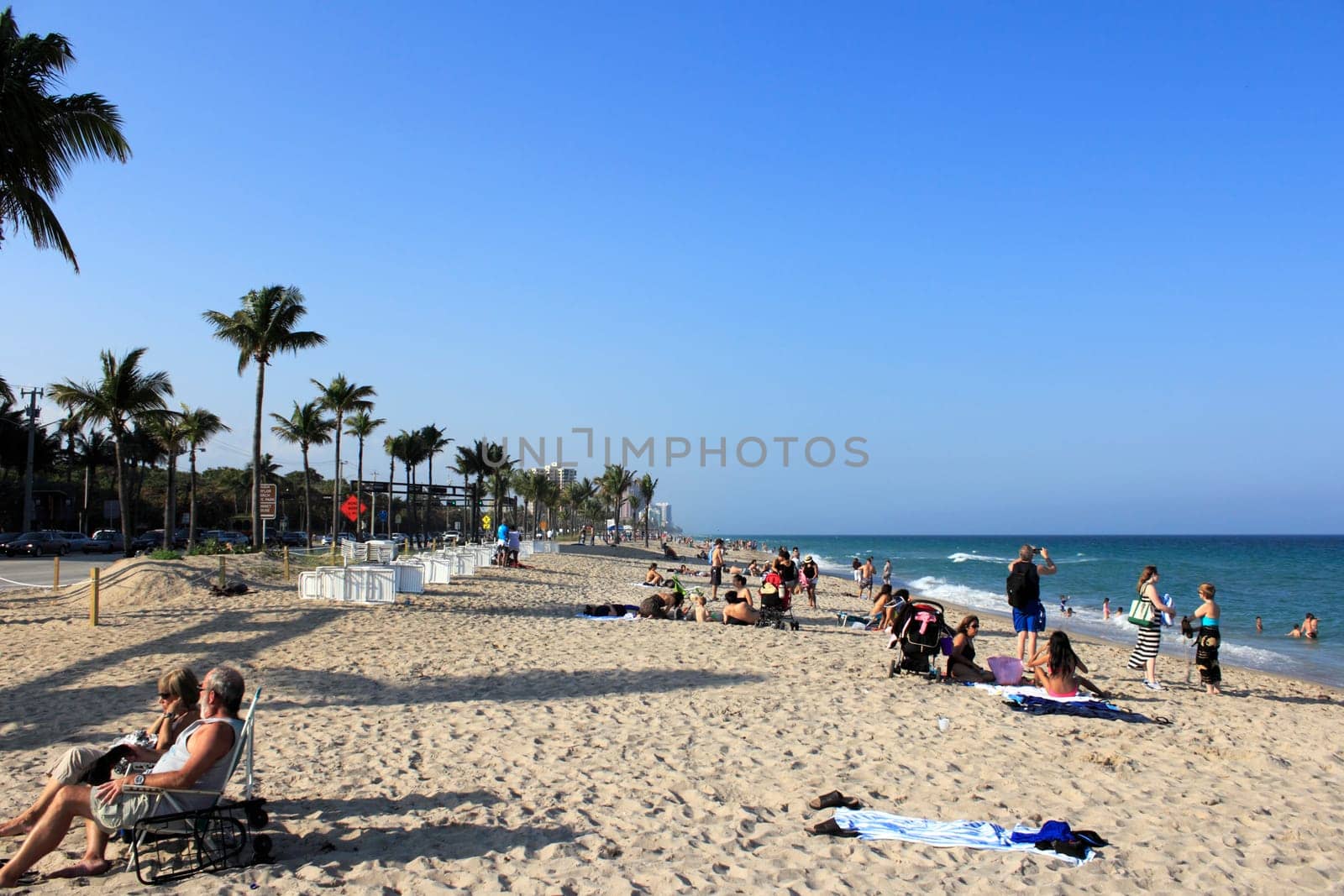 FORT LAUDERDALE, FLORIDA - MARCH 23, 2013: Atlantic coast beach at the end of Sunrise Boulevard during spring break with a wide variety of people relaxing in nature during the late afternoon.