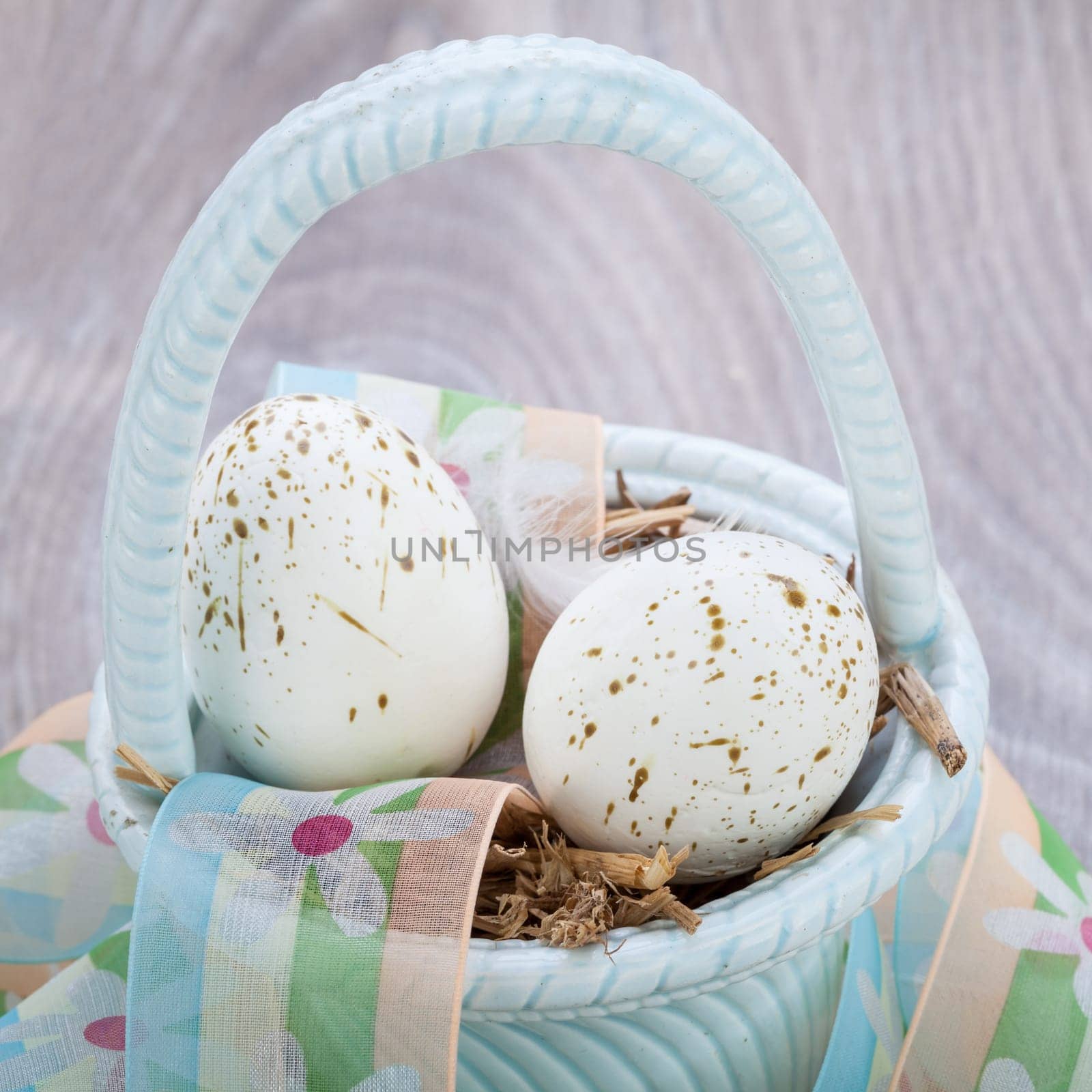 Three colorful bright Easter eggs in a basket on a wooden table Easter decoration custom spring festive