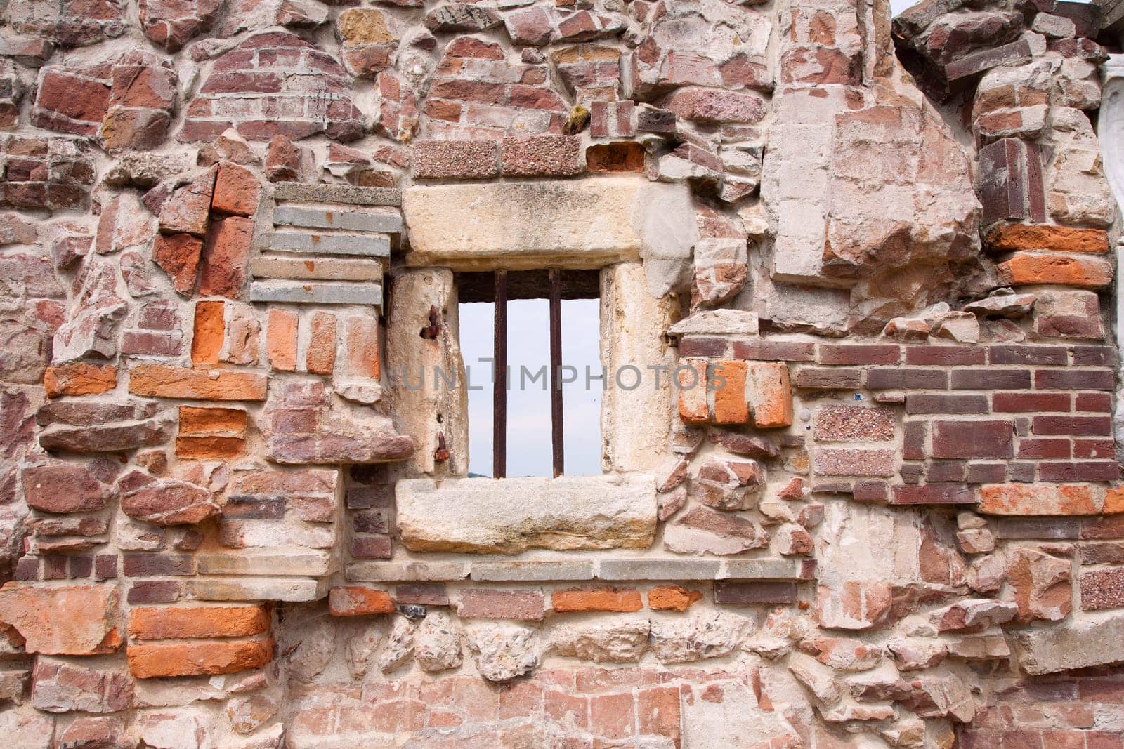 Stone wall made of a variety of rocks and bricks.