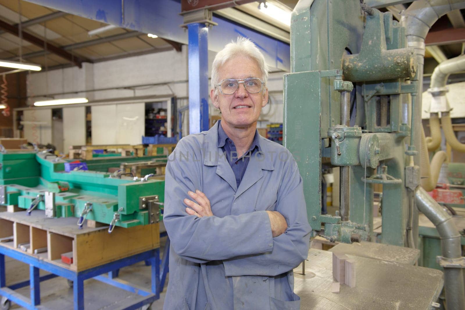 portrait of senior worker on factory floor next to machine