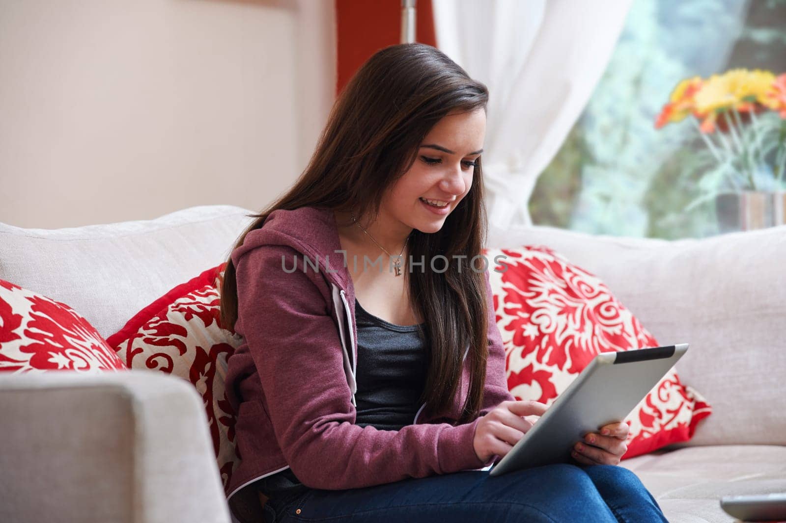 Teenage girl using a tablet pc while sitting at home