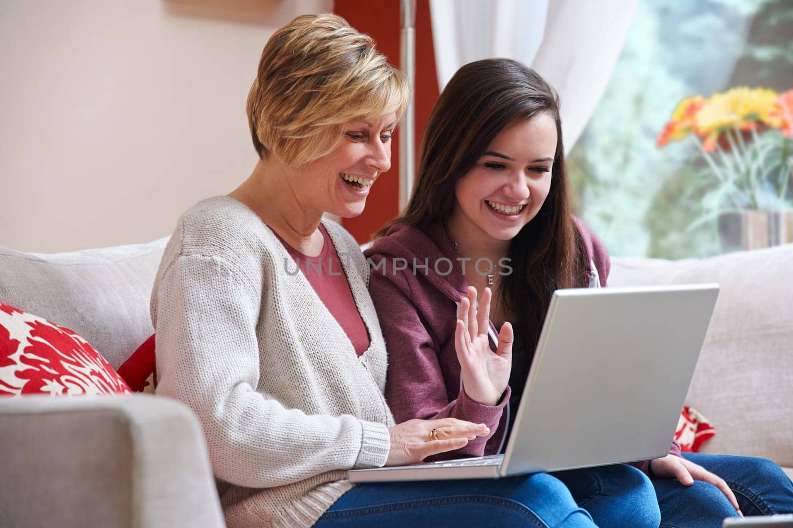 Mother and daughter enjoying surfing on the net while relaxing at home with coffee