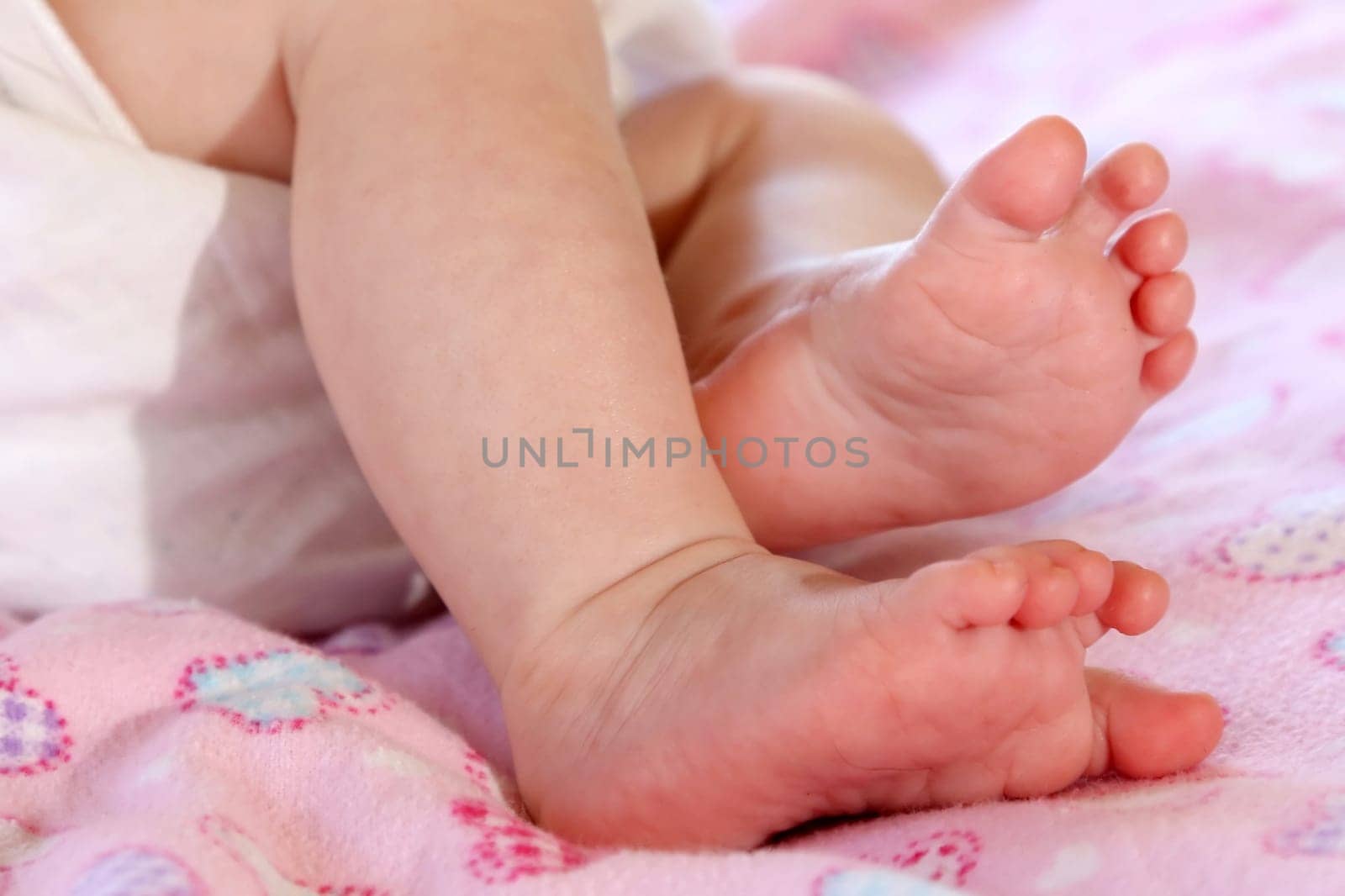 Baby's cute feet against a pink background