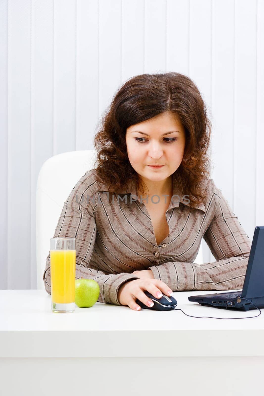Young woman in office looks at a glass of juice